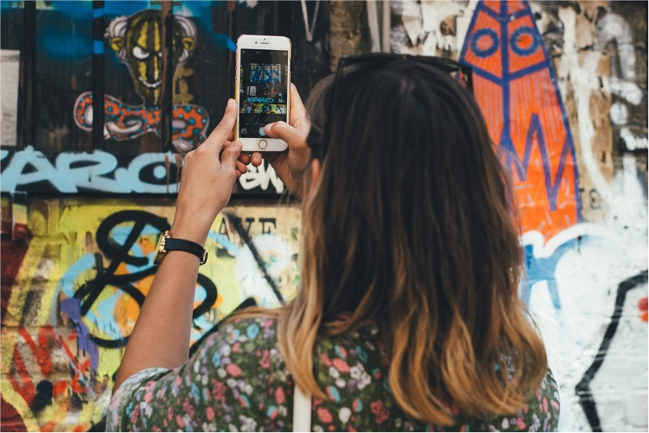 Een jonge vrouw die een foto maakt van street-art